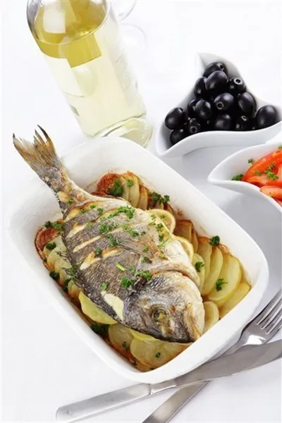 Дорада, запеченная с лимонным соком, петрушкой и сливочным маслом