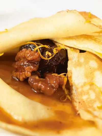 Пшеничные блинчики с соусом из чернослива, грецких орехов и апельсинового сока