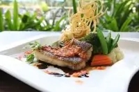 Морской окунь под винным соусом с томатами и перцами