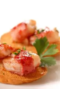 Маринованные креветки в кусочках прошутто на гриле