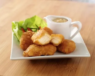 Золотистые куриные кусочки в кукурузных хлопьях с абрикосовым соусом