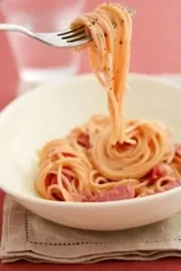 Салат из розовых макарон с ветчиной, лимоном и орехами