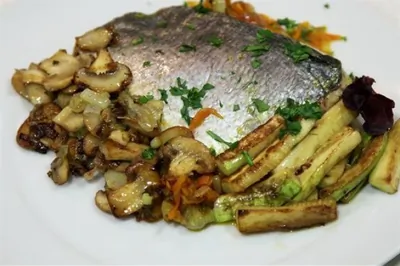 Дорада, запеченная на овощной подушке, в бумажном конверте