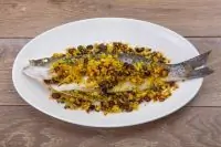 Сибас, запеченный с кедровыми орешками и изюмом