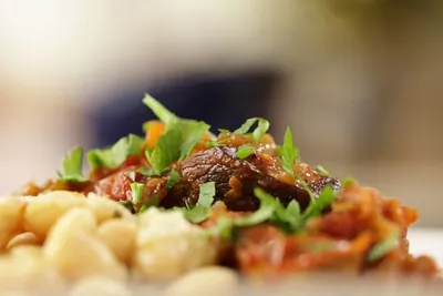 Телячья голяшка, тушеная с помидорами и красным вином