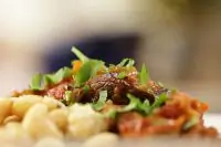 Телячья голяшка, тушеная с помидорами и красным вином