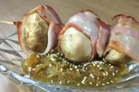 Шампиньоны, запеченные в беконе на подушке из кабачков