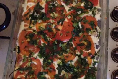 Куриное филе, запечённое в яично-сметанном соусе, с зеленью и помидорами