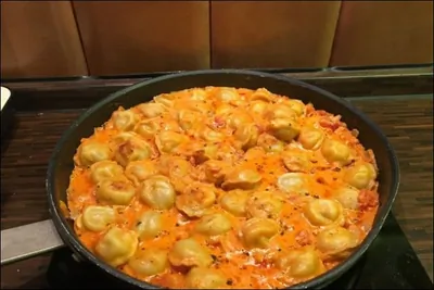 Тушеные пельмени с луком, томатами, сметаной и вустерширским соусом