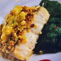 Гратен из сибаса под соусом из вина карменер, с травами, шпинатом, каштанами и пиньонес