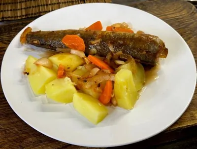 Хек запеченный в томатном соусе с луком и морковью
